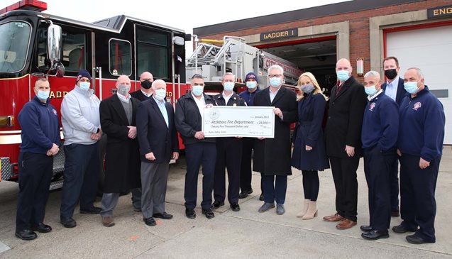 Attleboro Fire Department holding up donation check