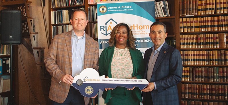 Jeff Bradley, Cheryl Galloway and John Silva holding large key in front of RI AnchorHome banner